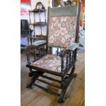 An American stained wood framed rocking chair with upholstered back, seat and arms