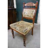 A set of four Edwardian walnut framed dining chairs with carved top rails, spindles and back and