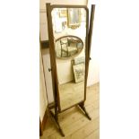 An early 20th Century mahogany framed cheval mirror with shaped top and bevelled plate, set on