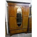 A 4' 3" Edwardian inlaid mahogany wardrobe with bevelled oval mirror panel door and single long