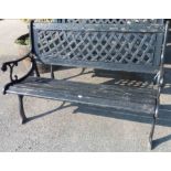 A cast iron framed garden bench with lattice back and slatted wooden seat