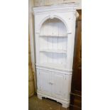 A 34" painted wood barrel back corner unit with dentil cornice and three open shelves over a pair of