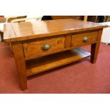 A 3' 4" antiqued stained pine coffee table with two through drawers and undertier, set on square
