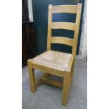 A set of six blonde wood ladder back dining chairs with rush seats, set on square supports