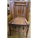 An antique elm framed spindle back chair with solid seat and turned supports