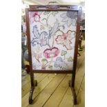 An early 20th Century Oriental style hardwood framed fire screen with tapestry upholstered rise