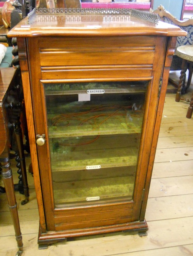 A 19½" late Victorian walnut music cabinet with pierced brass gallery and velvet lined named shelves