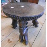 A 15" diameter Malawi carved hardwood stool with incised decoration and decorative frieze, set on