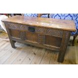 A 3' 6½" antique carved oak coffer with internal candle box and triple panel front, set on high