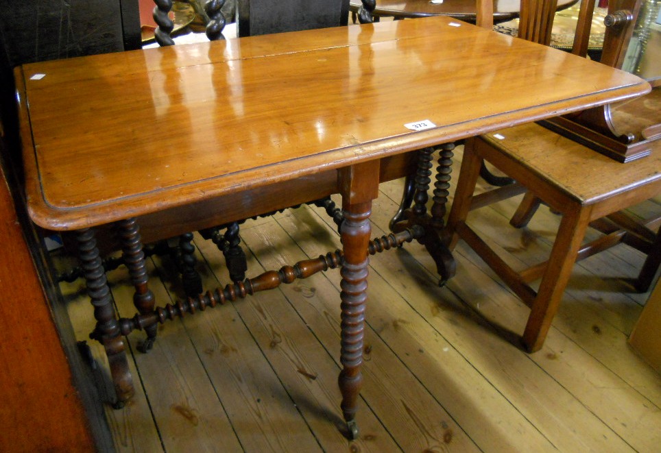 A 3' 2" Victorian walnut Sutherland table, set on twin flanking bobbin turned supports and uniting