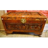 A 35" Oriental camphor wood chest with all over carved decoration, featuring figures in garden