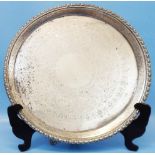 A 13¾" diameter Mappin Brothers silver salver with cast rim and engraved decoration, set on triple