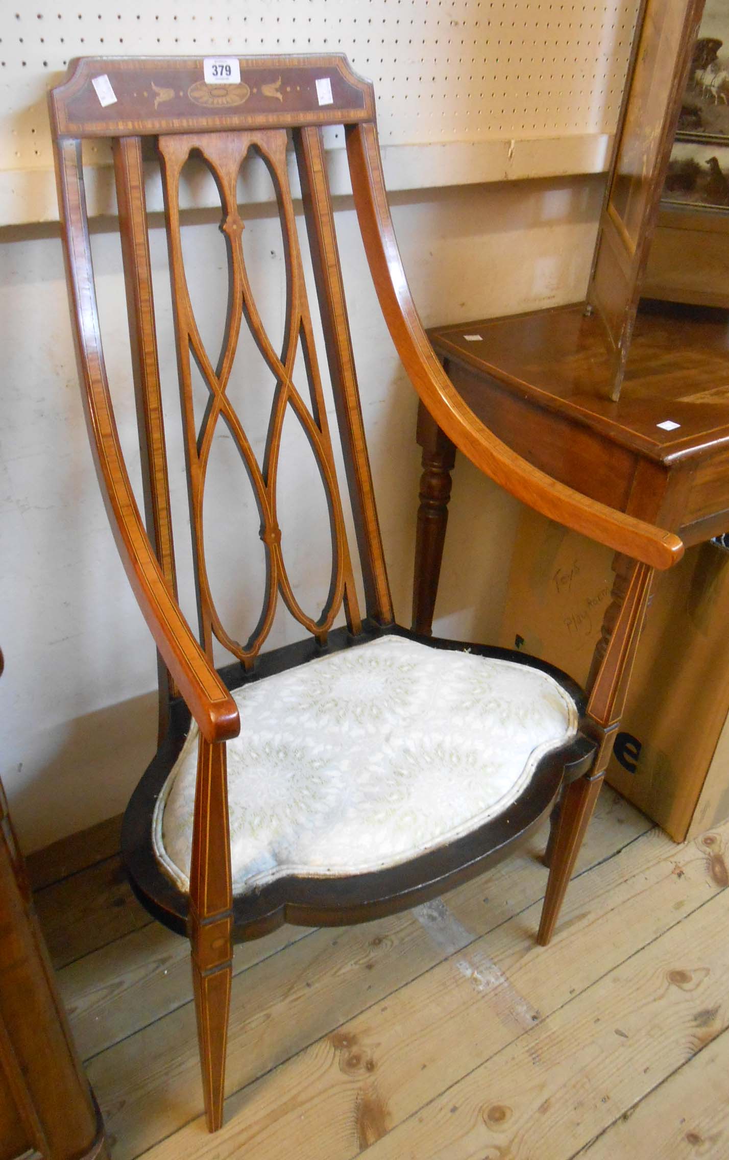 An Edwardian inlaid mahogany cross banded and strung swept elbow chair with pierced ribbon back