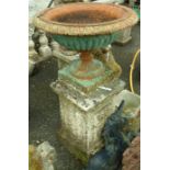 A 15½" Victorian cast iron urn planter set on a 25½" stone pedestal