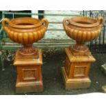 A pair of 3' 4½" 19th Century treacle glaze urns set on pedestal bases – one urn a/f