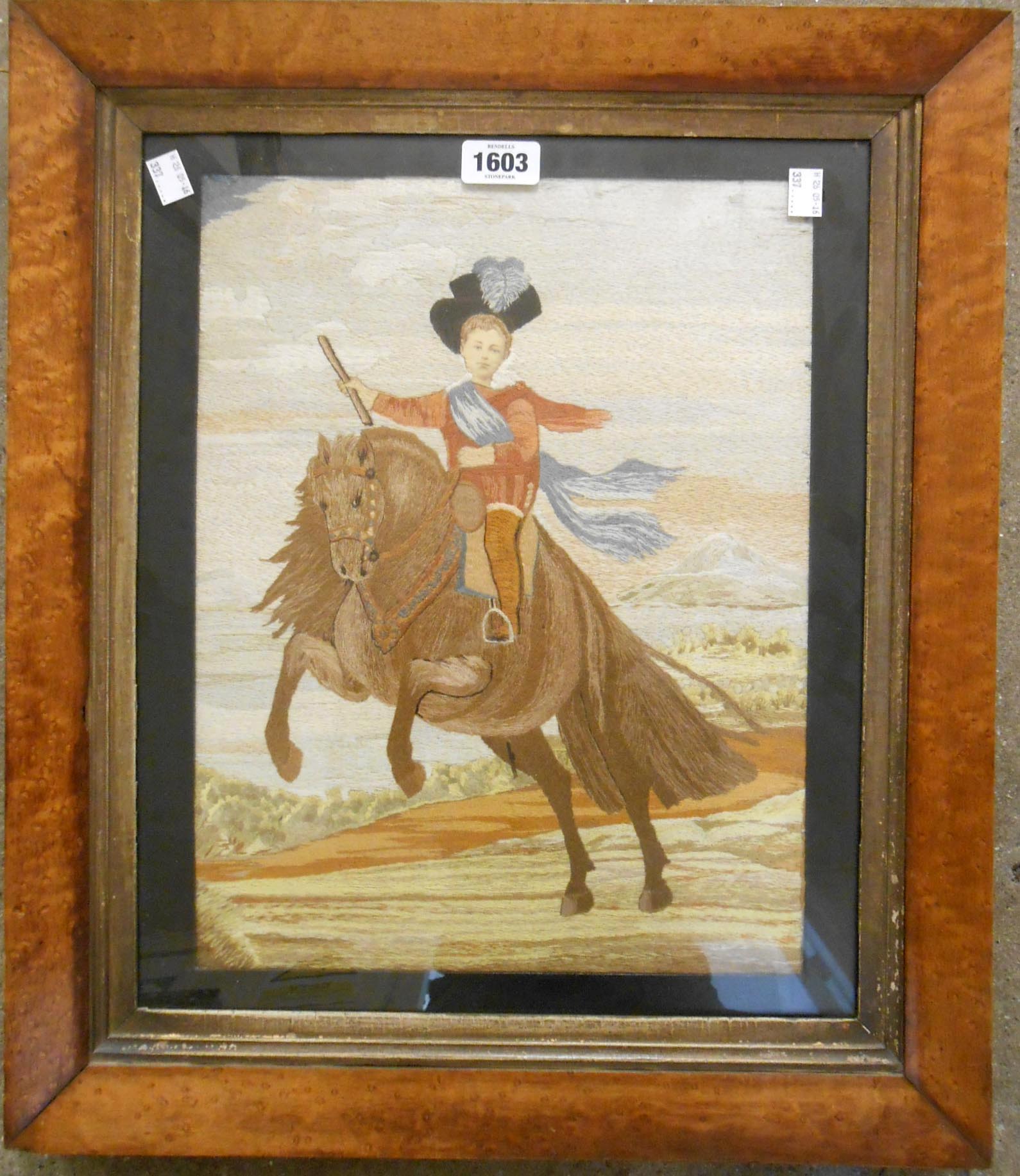 A mid 19th Century maple framed embroidered picture depicting a young child riding on horseback,