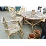 A teak cartwheel garden table - sold with four teak chairs of rustic design