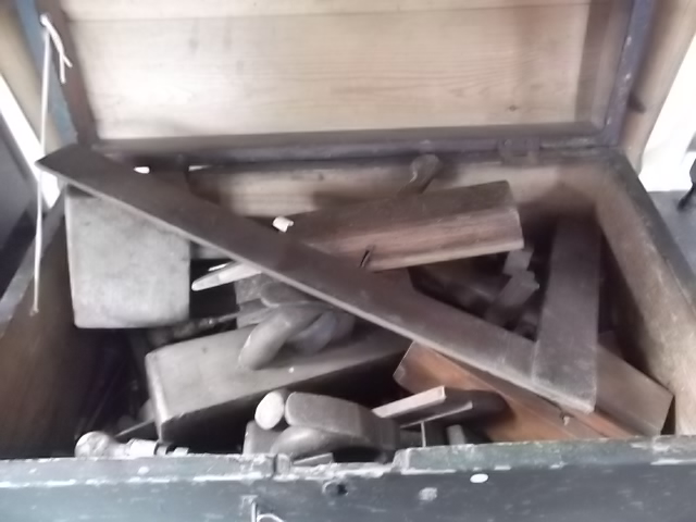 A chest containing various old joiners tools
