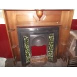 A tiled cast iron fireplace with mahogany surround