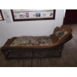 A Jacobean style dark oak day bed with angled head rest & squat turned supports