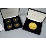 TWO BOXES OF COINS, to include four commemorative coins and one large gold plated coin, with