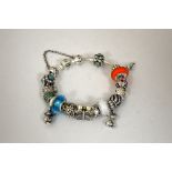PANDORA - A SILVER CHARM BRACELET, with sixteen charms and charm lock safety chain, with original