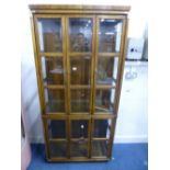 AN OAK GLAZED FOUR DOOR DISPLAY CABINET, with bevelled glass panels