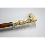A BONE HANDLED WALKING CANE, with carved grape and leaf detail, white metal monogrammed band over