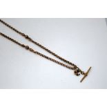 AN EARLY 20TH CENTURY ROSEGOLD T-BAR AND ALBERT CHAIN, with fancy spacers and faceted ball detail,