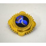 AN ENAMELLED BROOCH, depicting a blue bird within a fancy scalloped border, with vacant back panel