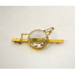 A TOPAZ BROOCH, with circular topaz to the fancy bar, stamped 15c to the front