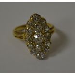 AN OVAL DIAMOND CLUSTER RING, with three central diamonds surrounded by twelve smaller diamonds,