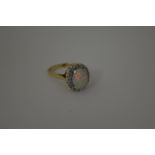 A 9CT GOLD OPAL AND DIAMOND RING, with central opal within a surround of single cut diamonds,