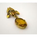 A VICTORIAN PENDANT, with citrine coloured oval faceted stone with fancy scrolling surround with