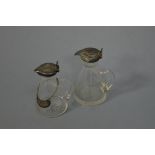 TWO SILVER TOPPED CORNICAL GLASS JUGS, Birmingham 1907, largest approximately 10.5cm high to top