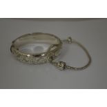 TWO BRACELETS, to include an engraved hinged bangle, together with a charm bracelet, hallmarks for