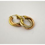A PAIR OF 9CT GOLD EARRINGS, designed as three coloured metals twisted together into a hoop,