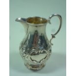 A VICTORIAN SILVER CREAM JUG, with embossed floral and leaf decoration, vacant cartouches, London