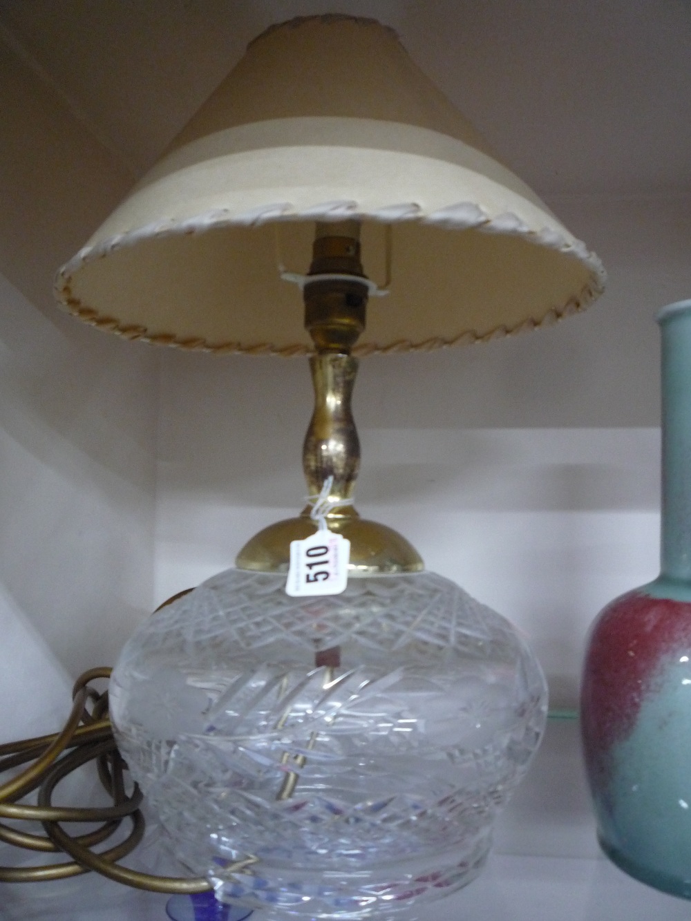 A CUT GLASS LAMP BASE, with shade