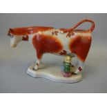 A 19TH CENTURY PEARLWARE STAFFORDSHIRE COW CREAMER, painted in iron red enamels, loop tail, base