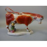 A 19TH CENTURY PEARLWARE STAFFORDSHIRE COW CREAMER, painted in iron red enamels, loop tail, base