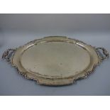 A HEAVY SILVER TRAY, of shaped oval form with scroll decoration to twin handles, Birmingham 1947,