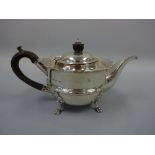 A SILVER TEAPOT, with ebonised handle and finial, wavy rim set on four paw feet, Birmingham 1903,