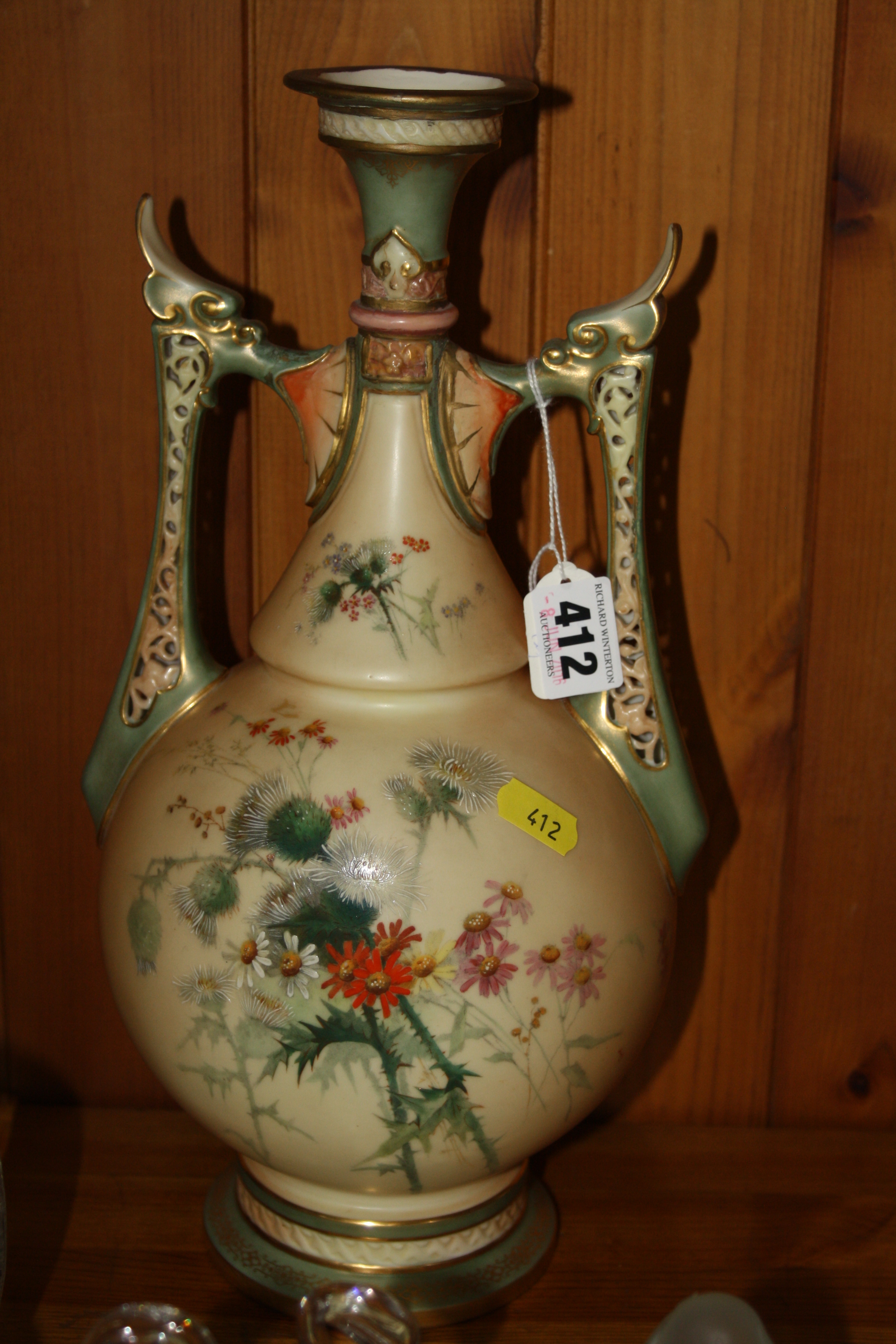 A ROYAL WORCESTER PORCELAIN TWIN HANDLED VASE, decorated with thistles and flowers on cream ground