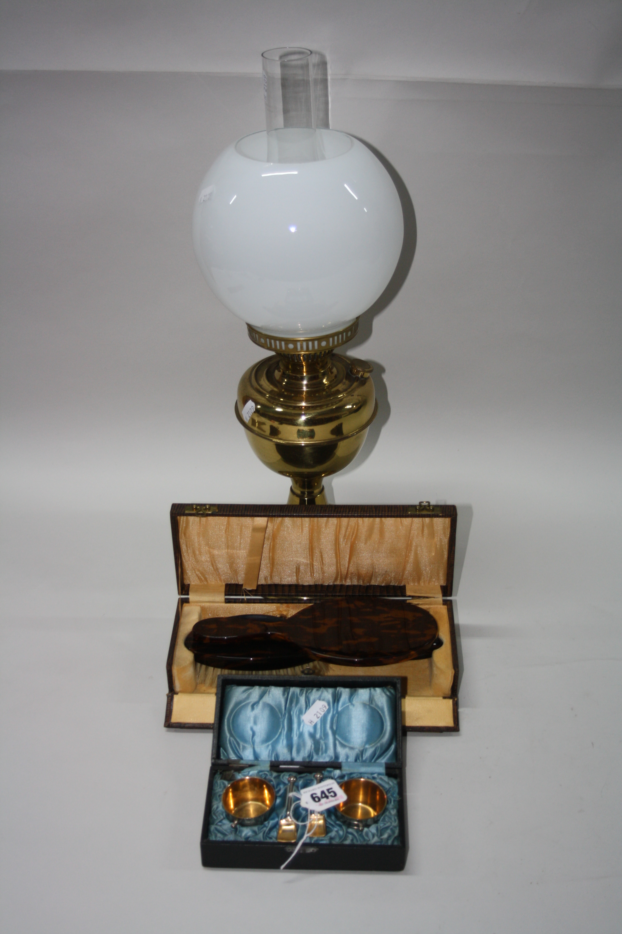 A CASED NOVELTY SALT SET, a cased brush set and an oil lamp (3)