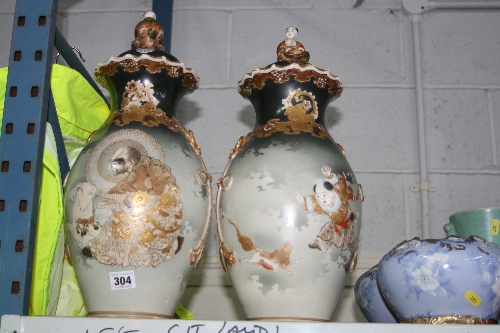 A PAIR OF ORIENTAL VASES AND COVERS, of baluster form with gilt relief highlighted figural