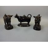 THREE 19TH CENTURY BLACK GLAZED 'JACKFIELD' COW CREAMERS, with gilt highlights, all with loop tails,