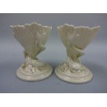 A PAIR OF ROYAL WORCESTER TABLE SALTS, in the form of shell being supported by fish on circular