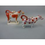 TWO 19TH CENTURY STAFFORDSHIRE PEARLWARE COW CREAMERS, the iron red example set on oval plinth (a/f,