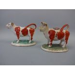 TWO 19TH CENTURY STAFFORDSHIRE PEARLWARE COW CREAMERS, decorated with iron red patches, loop tail
